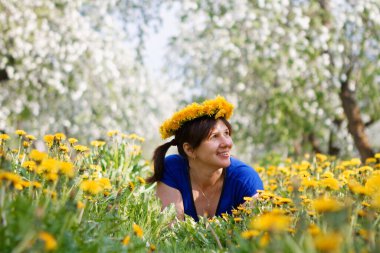 2020 'de çiçek açan elma bahçesindeki kadın ve karahindiba tarlası.