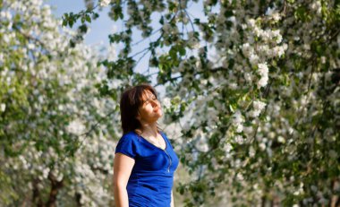 2020 'de çiçek açan elma bahçesindeki kadın ve karahindiba tarlası.