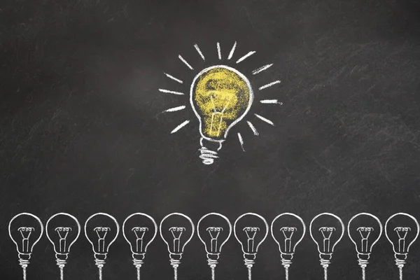 Light bulbs with an idea light bulb on chalkboard