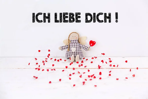 Little angel doll with a balloon heart and a \'Ich liebe dich\' text. Translation: \'I love you\'