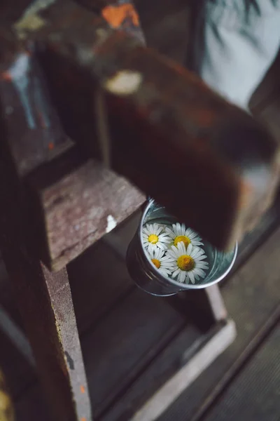 İçinde çiçekler olan ahşap bir büfeden sallanan bir kova. Yüksek kalite fotoğraf