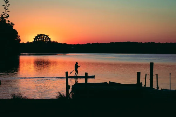Gün batımının önündeki gölde kürek çek. Yüksek kalite fotoğraf