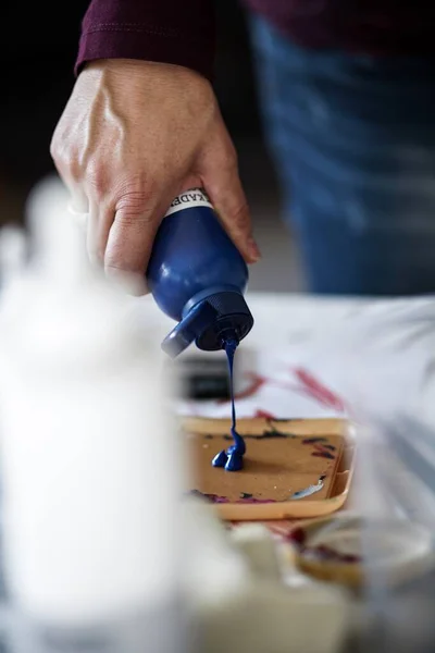 Sanatçı işi için akryl boyası hazırlıyor.