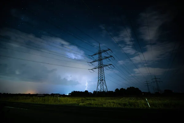 Bir fırtınanın önündeki elektrik hatları bir tarlanın üzerinde