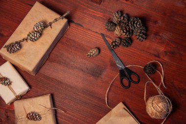 Tahtanın üzerinde çam kozalaklı makaslı el yapımı karton kutular. Düz yatıyordu