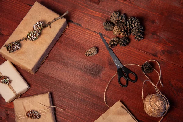 Tahtanın üzerinde çam kozalaklı makaslı el yapımı karton kutular. Düz yatıyordu