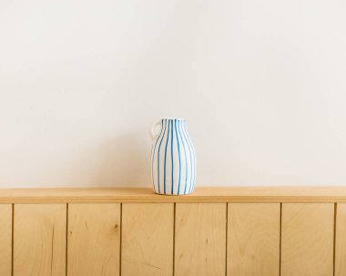 Çizgili sürahi masanın üstünde.