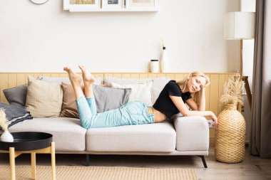 Güzel bir kadın kanepede dinleniyor.