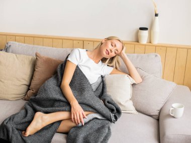 Güzel bir kadın kanepede dinleniyor.