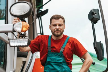 Male farm worker in rural outdoor setting. Agricultural machinery operator.