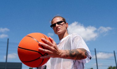 Young fashionable woman with basketball, urban street style.