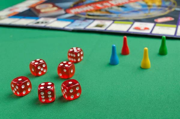 Rote Würfel für Brettspiele mit Chips auf grünem Hintergrund — Stockfoto