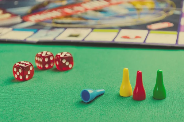 Rote Würfel für Brettspiele mit Chips auf grünem Hintergrund — Stockfoto