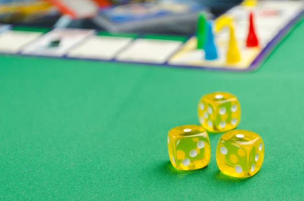 Gelbe Spielwürfel für Brettspiele auf grünem Hintergrund — Stockfoto