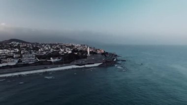 Gün batımında şehrin ve deniz fenerinin havadan görünüşü