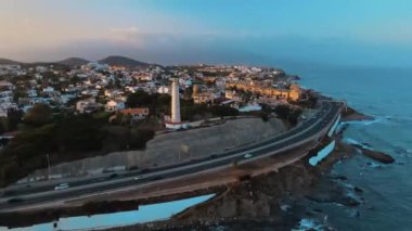 Gün batımında şehrin ve deniz fenerinin havadan görünüşü