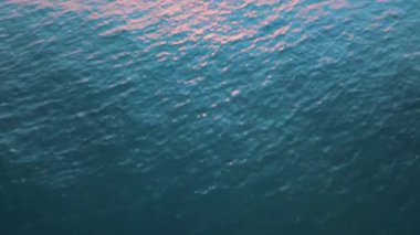 Gün batımında ufka doğru eğilen deniz manzarası.