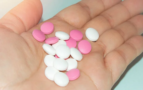 白とピンクの錠剤の束を持つ女性のオープンヤシ,健康と医学の概念,クローズアップ — ストック写真