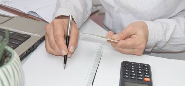 Kadınların elleri iş yerlerinde kredi kartı, vergi ve ödemeler için kullanırlar. İş için kredi kartı ödemesi