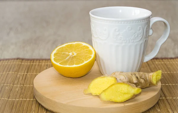 Чашка имбирного чая с медом и лимоном на деревянном круглом натуральном подносе, обработанном дома — стоковое фото
