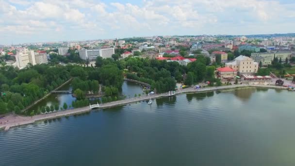 Lotnicze lot widok na park i piękne, Błękitne jezioro w centrum miasta. Tarnopol, Ukraina. Ludzie są odpoczynku w parku miejskim — Wideo stockowe
