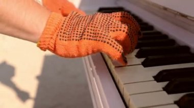 Bir piyanist elleri üzerinde klavye çalmaya eldivenli Close-up. Mens elle piyano klavye eldiven. Sokak piyano.