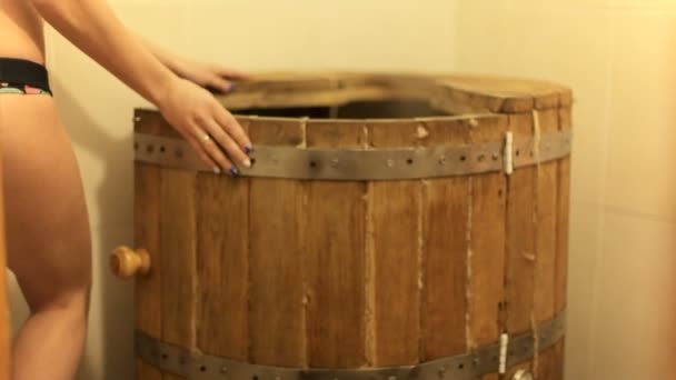 Mooi meisje gaat in een vat van de ceder — Stockvideo