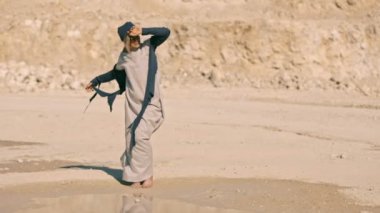 zarif kız bir kaya arka planı bir gölün kıyısında duruyor. Dişi Büyücü.