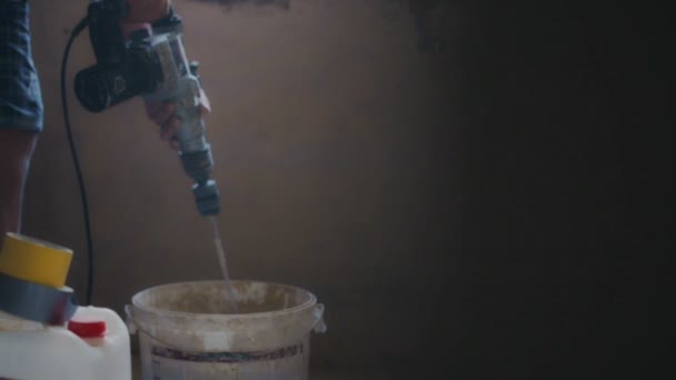 Elektrische mixer mixt cement in een emmer op een bouwplaats — Stockvideo