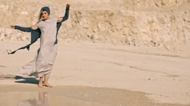 etnik elbiseler bir kaya arka planı lake yakınındaki dans zarif kız.