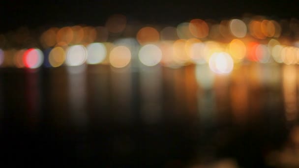 Lumineux beau bokeh coloré sur un fond sombre. Réflexion des lumières dans l'eau sombre — Video