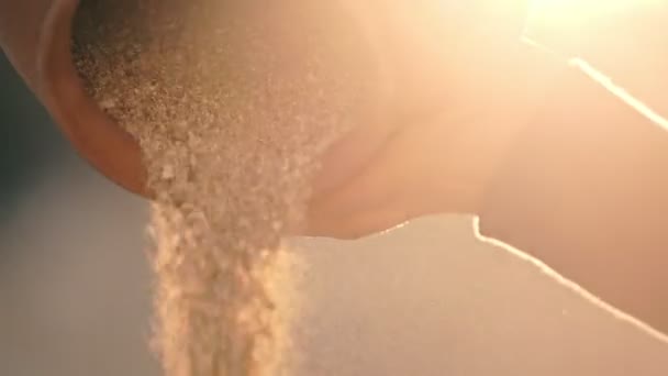 Девушка высыпает золотой песок из блестящей на солнце глиняной банки. Вода превратилась в золотой песок — стоковое видео