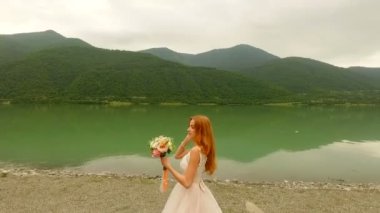 Güzel ve mutlu gelin ve damat nehir kıyısında. Gelin düğün buket atar