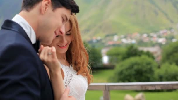 День свадьбы. Чувственная невеста и жених на фоне высоких гор влюблены и нежны. Казбеги, Грузия — стоковое видео