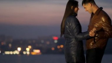 Mutlu aşıklar kucaklamak ve bir gece şehir arka planı dans. hassasiyet aşk. Romantik akşam