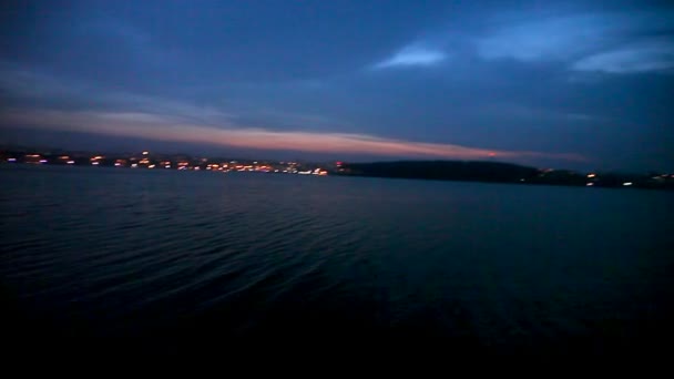 Cidade noturna com luzes no fundo do lago e no céu noturno — Vídeo de Stock