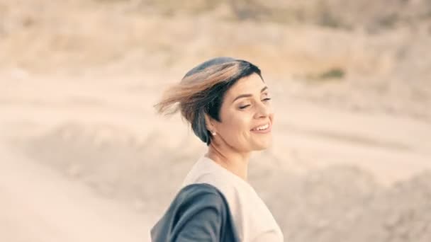 Щаслива дівчина босоніж танцює на білій дорозі — стокове відео