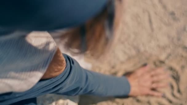 Egy gyönyörű és álmodozó fiatal nő felhívja a homok. közeli kép:. — Stock videók