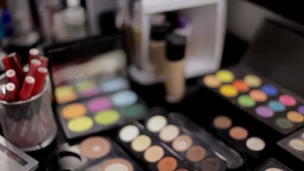 Cosmetici professionali nel salone di trucco. Cosmetici di lusso per il trucco. Rossetto multicolore, ombre, polvere, matite primo piano — Video Stock