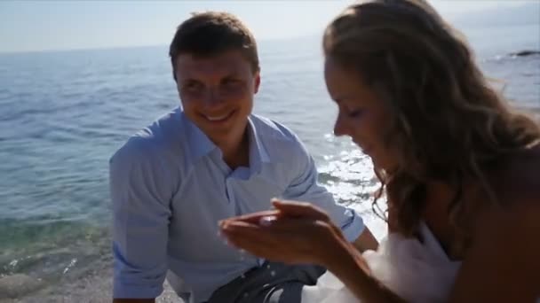 Heureux et joyeux mariés sont assis sur la plage le jour de leur mariage — Video