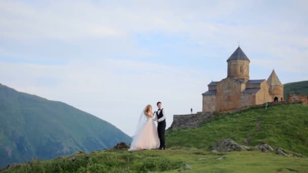 День свадьбы. Любящая пара на фоне гор. Казбеги, Грузия — стоковое видео