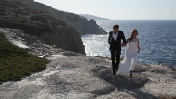 Novia y novio felices en la orilla del mar el día de su boda. El concepto de una vida familiar feliz — Vídeos de Stock