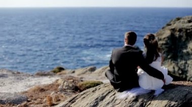 Mutlu gelin ve damat düğün günlerinde sahil üzerinde şefkatle kucaklamak.