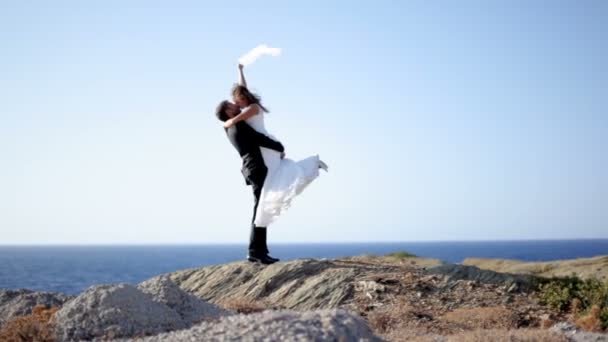 Heureux mariés embrasser tendrement sur le bord de la mer le jour de leur mariage . — Video