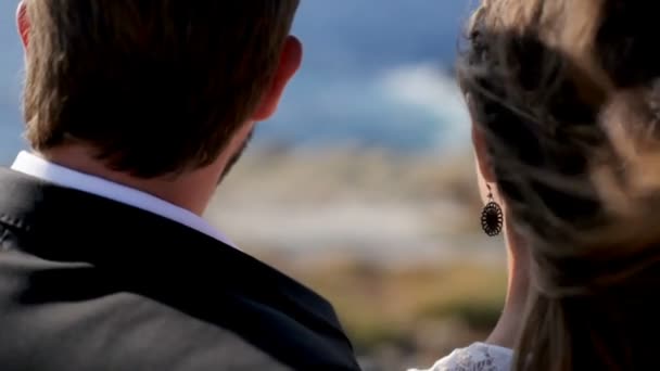 Happy bride and groom tenderly embrace on the seashore on their wedding day. — Stock Video