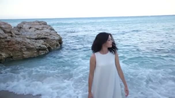 Une belle brune est triste au bord de la mer d'avoir mis fin aux vacances et doit rentrer chez elle. Grèce — Video