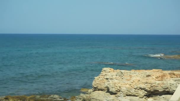 L'eau bleue de mer transparente lave le rivage de pierre. Grèce — Video