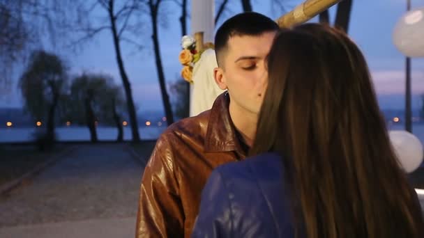 Красивий чоловік і жінка цілуються в парку на романтичному побаченні — стокове відео