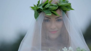 Güzel gelin duvak bir buket çiçek ile altında. Gizemli görüntü