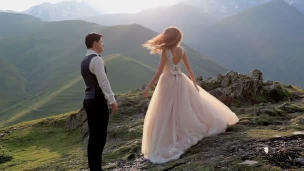 Una splendida sposa e lo sposo il giorno del loro matrimonio sullo sfondo delle maestose montagne. Georgia. Il concetto di una vita coniugale felice — Video Stock